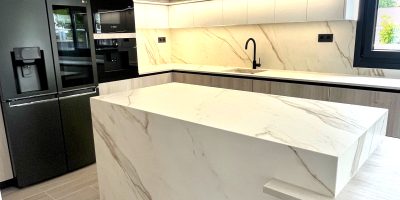 Isla central Calacatta Gold en cocina blanca